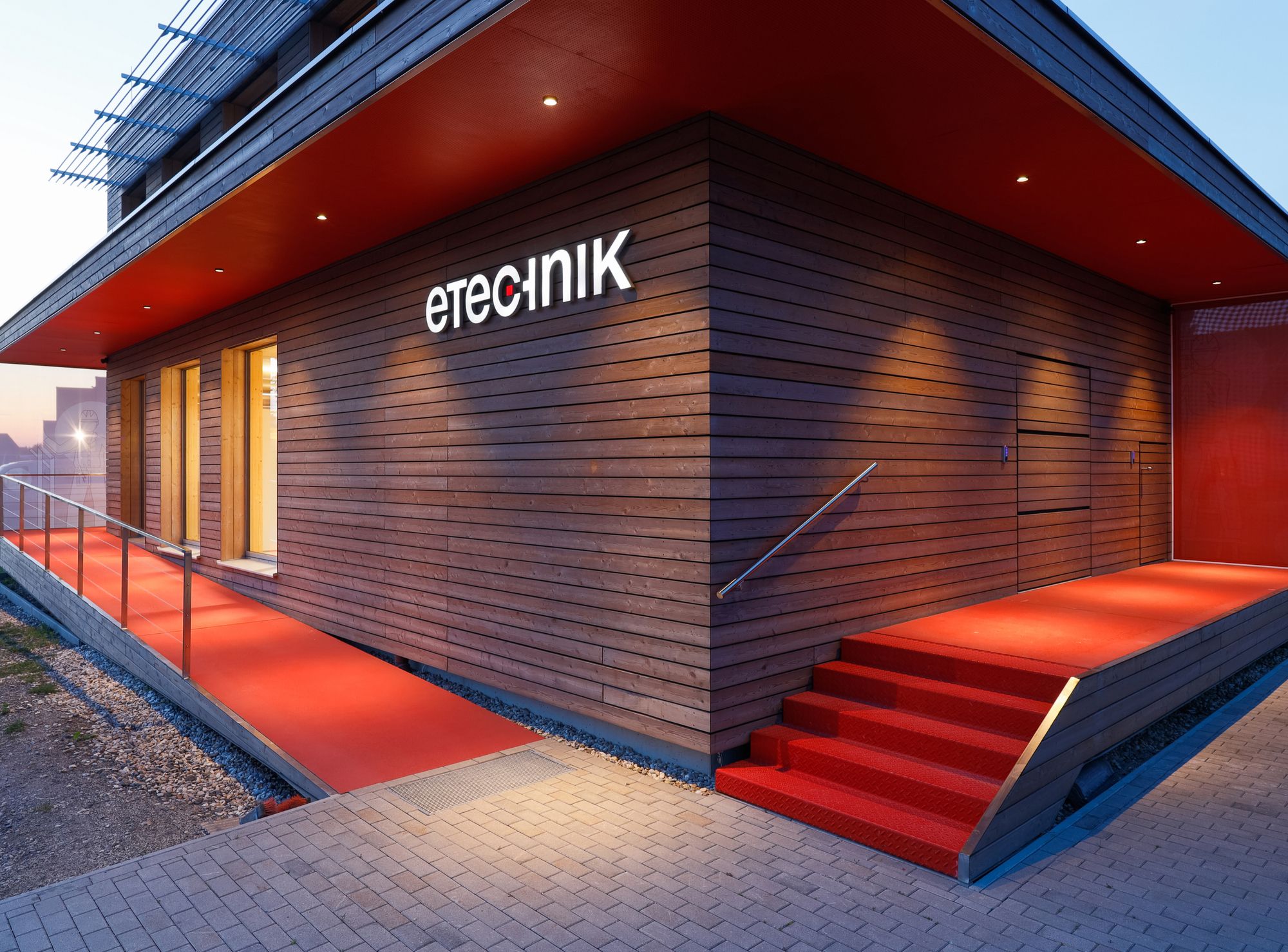 Modernes Firmengebäude mit beleuchtetem Eingangsbereich